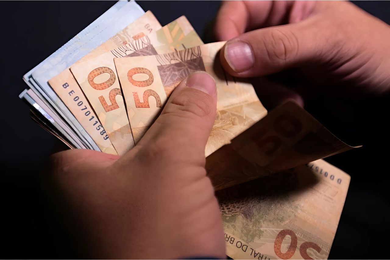 Empresário contando dinheiro para pagar o marketing digital
