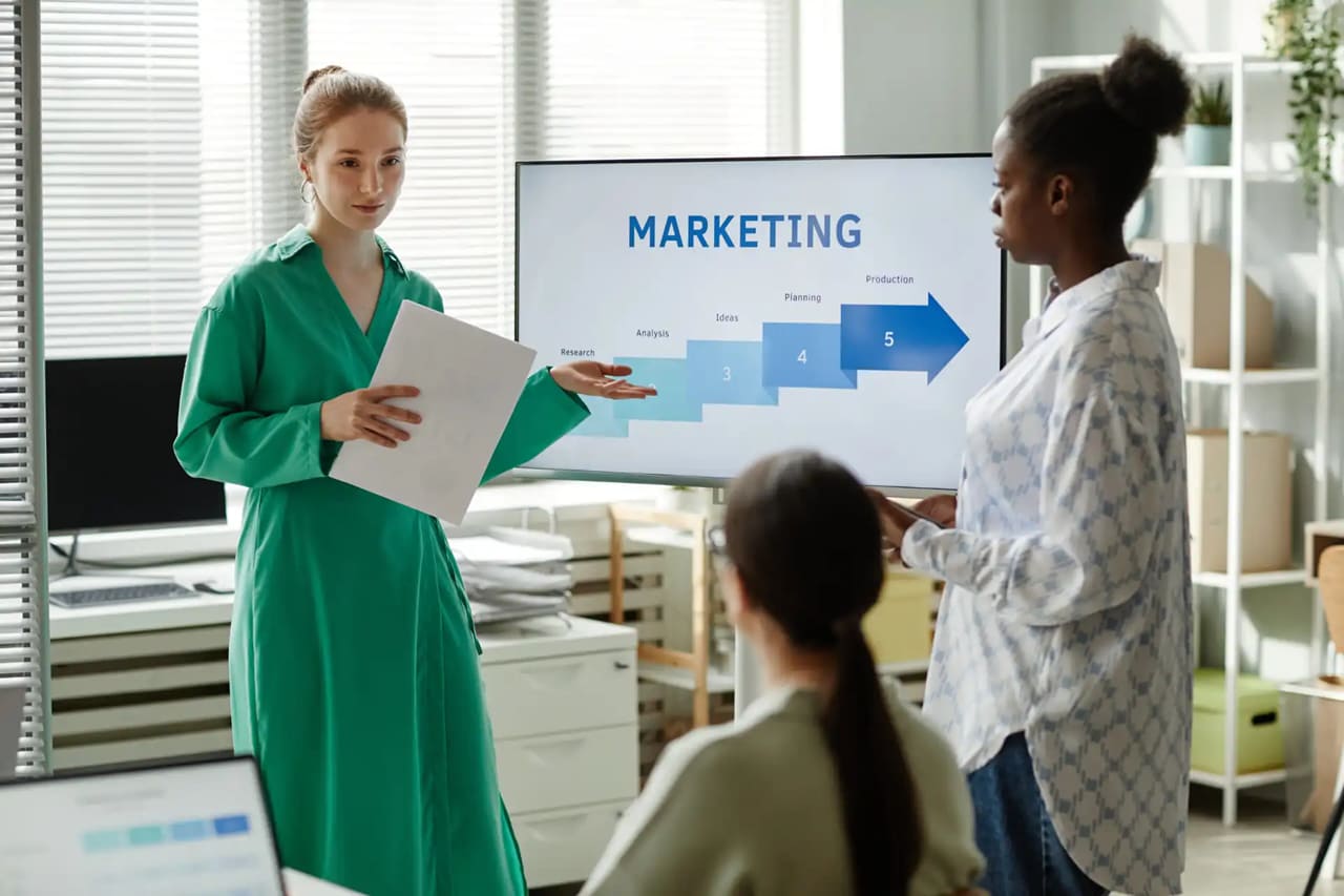 Profissionais reunidos em uma agência de marketing digital analisando gráficos e campanhas.
